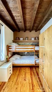 a bedroom with two bunk beds and a wooden ceiling at Casa Neira in La Riera