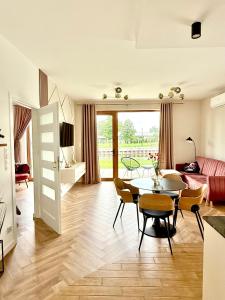 a living room with a table and a couch at Apartament River in Pisz