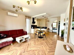 a living room with a red couch and a table at Apartament River in Pisz