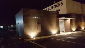 a building with lights in a parking lot at night at Hotel la Posada de Roces in Gijón