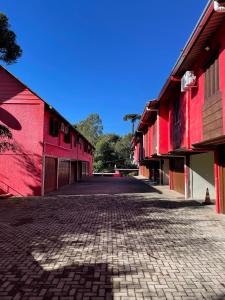 a cobblestone street between two red buildings at Agha Motel in Canela