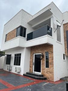 een wit en rood bakstenen huis met een raam bij Albuquerque in Abeokuta