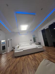 een slaapkamer met een groot bed in een kamer met houten vloeren bij Albuquerque in Abeokuta