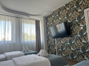a hotel room with two beds and a tv on the wall at Hotel Restauracja Twist in Krosno