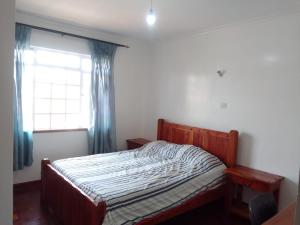 a bedroom with a bed and a window with curtains at Runda Paradise1 in Nairobi