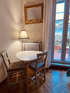 une table et des chaises avec une lampe et une fenêtre dans l'établissement Suite con terrazzo, à Milan