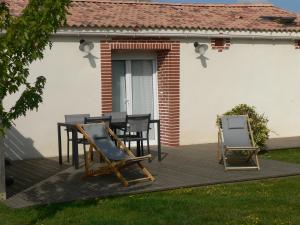 een terras met een tafel en stoelen erop bij La Mariennaye in Beaurepaire
