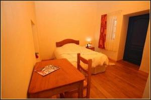 a small bedroom with a bed and a table at Chaquill Chak'a in Cusco