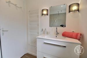 a white bathroom with a sink and a mirror at Penty breizh in Penvénan