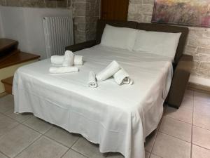 a white bed with towels on top of it at Bella Vita Apartment in Ruvo di Puglia +1 photo