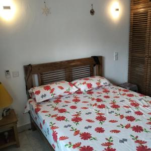 a bedroom with a bed with red flowers on it at Fiocco di neve in Watamu