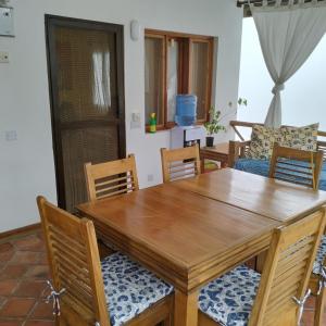 a dining room with a wooden table and chairs at Fiocco di neve in Watamu +5 photos