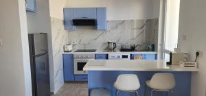 a kitchen with blue cabinets and white appliances at Argaka Breeze sea view apartment in Argaka