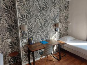 1 dormitorio con escritorio, cama y pared en Le Royalty, en Angers