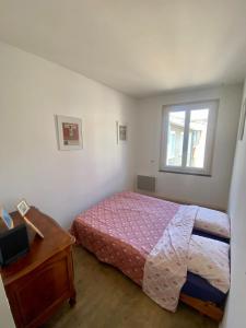 a bedroom with a bed and a desk and a window at Gîte Massibel au coeur de Brassac in Brassac