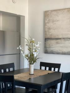 un tavolo nero da pranzo con un vaso di fiori sopra di LR Little River lovely 1 bedroom condo with pool a Little River