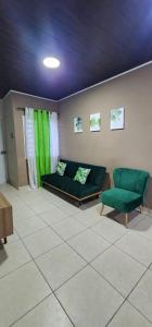 科马亚瓜Casa Villa Universitaria的客厅配有绿色沙发和两把椅子