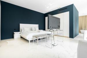 a bedroom with a white bed and a blue wall at Villa L'oasis, piscine intérieur, extérieur sauna, cinéma in Mougins +23 photos