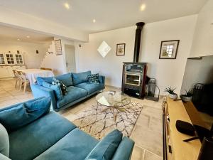 a living room with a blue couch and a stove at La Rose des Vents in Suzette