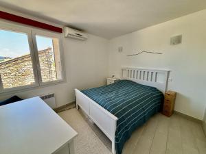 a bedroom with a bed and a table and a window at La Rose des Vents in Suzette