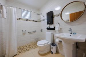 a bathroom with a toilet and a sink and a mirror at Ulala Culebra in Culebra +80 photos