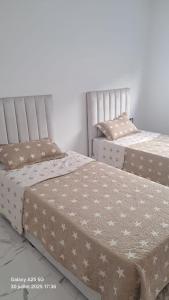 two beds sitting next to each other in a room at modern apartment in Tangier