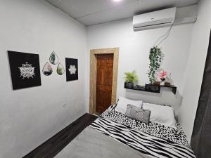 a bedroom with a bed with a black and white blanket at Comfy Carnival Rental in Port-of-Spain