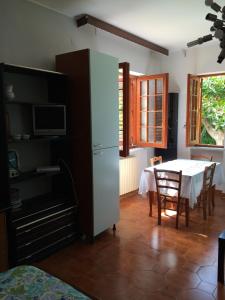 a dining room with a table and a white refrigerator at Villa DonnAnna in Cariati +24 photos