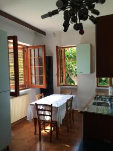 a kitchen with a white table and chairs and windows at Villa DonnAnna in Cariati
