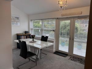 a dining room with a table and chairs and windows at Raddenstile, Exmouth in Exmouth
