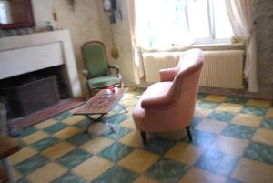 a living room with a chair and a fireplace at La caburoche de Charlemagne in Civray-de-Touraine