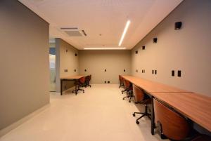 a long row of tables and chairs in a room at Studio b2b in Florianópolis