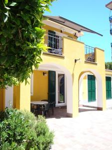 una casa amarilla con una mesa delante en Andoramare B&B, en Andora