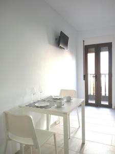 a white dining room with a white table and chairs at Sun Akademie in Las Palmas de Gran Canaria +9 photos