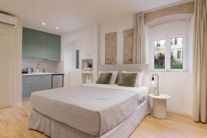 ein Schlafzimmer mit einem großen Bett und eine Küche in der Unterkunft Dousmani Old Town Studio in Korfu-Stadt