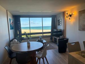 a living room with a table and a view of the ocean at Élégant T2 acces direct plage in Saint-Cyprien-Plage
