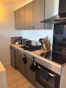 a kitchen with wooden cabinets and a stove top oven at Élégant T2 acces direct plage in Saint-Cyprien-Plage