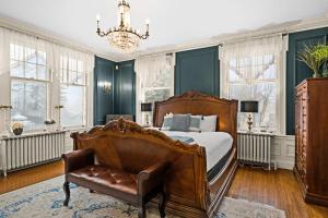 a bedroom with a bed and a chair and windows at Historic Salyards Mansion by Heirloom Boutique Collection in Duluth