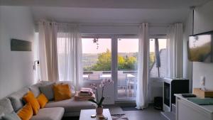 a living room with a couch and a large window at Les Adrets de Malmedy in Malmedy