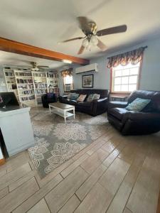 Una sala de estar con sofás y un ventilador de techo. en Private Beach Front house Newport, New Jersey, 