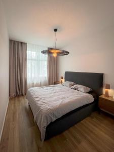 um quarto com uma cama grande e um lustre em Dzelzavas loft em Riga