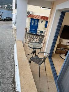 een tafel en stoelen buiten een gebouw bij GN apartment in Ayia Evfimia