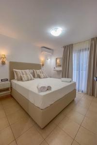 een slaapkamer met een groot bed en een groot raam bij GN apartment in Ayia Evfimia