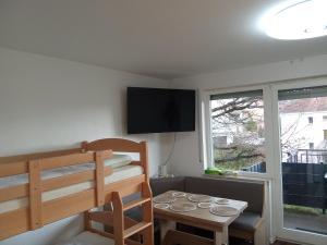 a small room with a bunk bed and a table at Casa Ludi Pforzheim Eutingen gute Wohngegend direkte Buchung möglich keine Freigabe erforderlich inklusive Balkon Terrasse und Tiefgaragenparkplatz im Haus in Eutingen