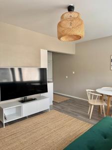 a living room with a flat screen tv and a table at Two-room apartment near the hospital in Joensuu