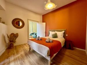 Un dormitorio con una cama con dos animales de peluche encima. en Suite Madeleine - Cœur Historique, en Béziers
