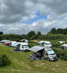 a group of rvs parked in a field at Camping de Haarakker in Langeveen