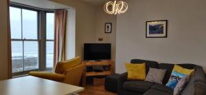 a living room with a couch and a tv at Luxury Sea View Apartment - One Bedroom in Aberystwyth