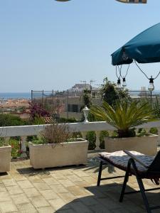 a patio with a chair and an umbrella and plants at Villa El Faro in Peñíscola