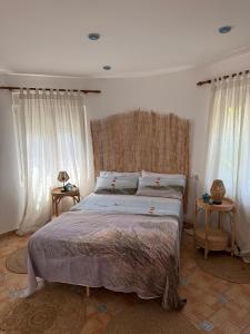 a bedroom with a large bed and two windows at Villa El Faro in Peñíscola